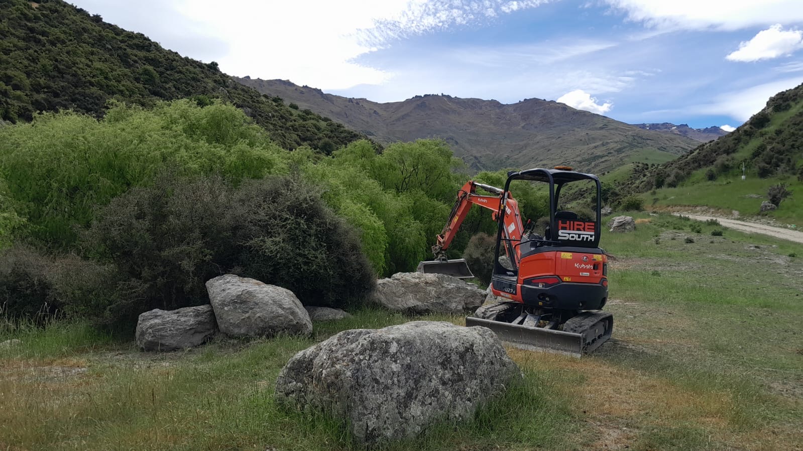 Hire South mini digger working among boulders in a mountain valley, Central Otago
